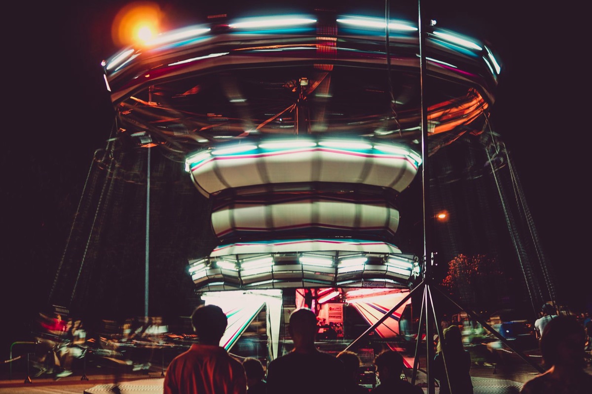 Atracción de un parque iluminada de noche con luces de colores